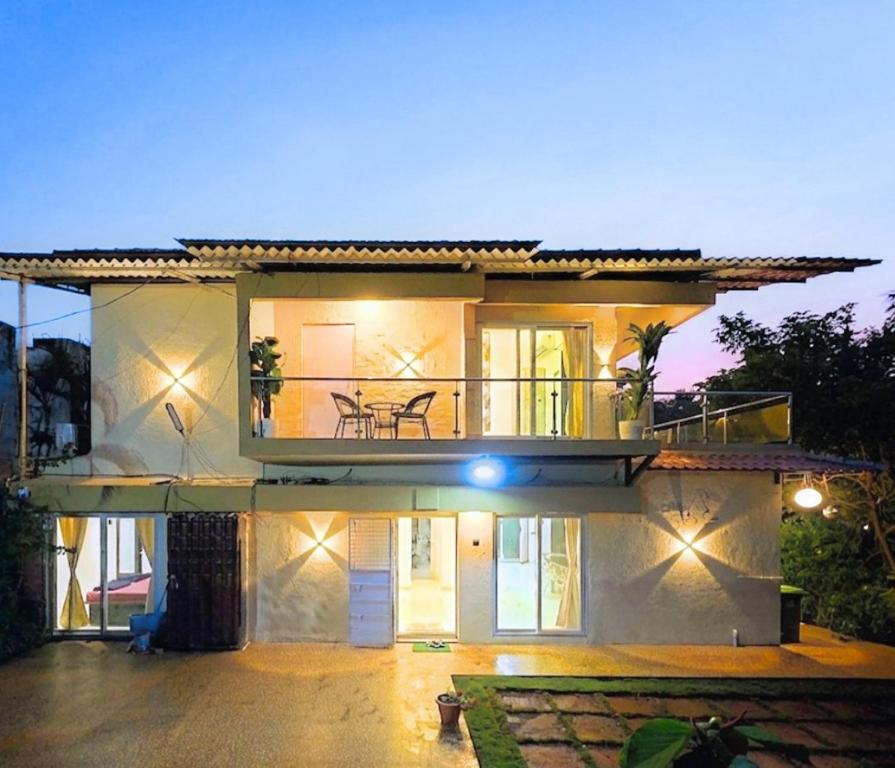 a large white house with a balcony at night at Eko Nest Grand 5BHK Villa in Lonavala