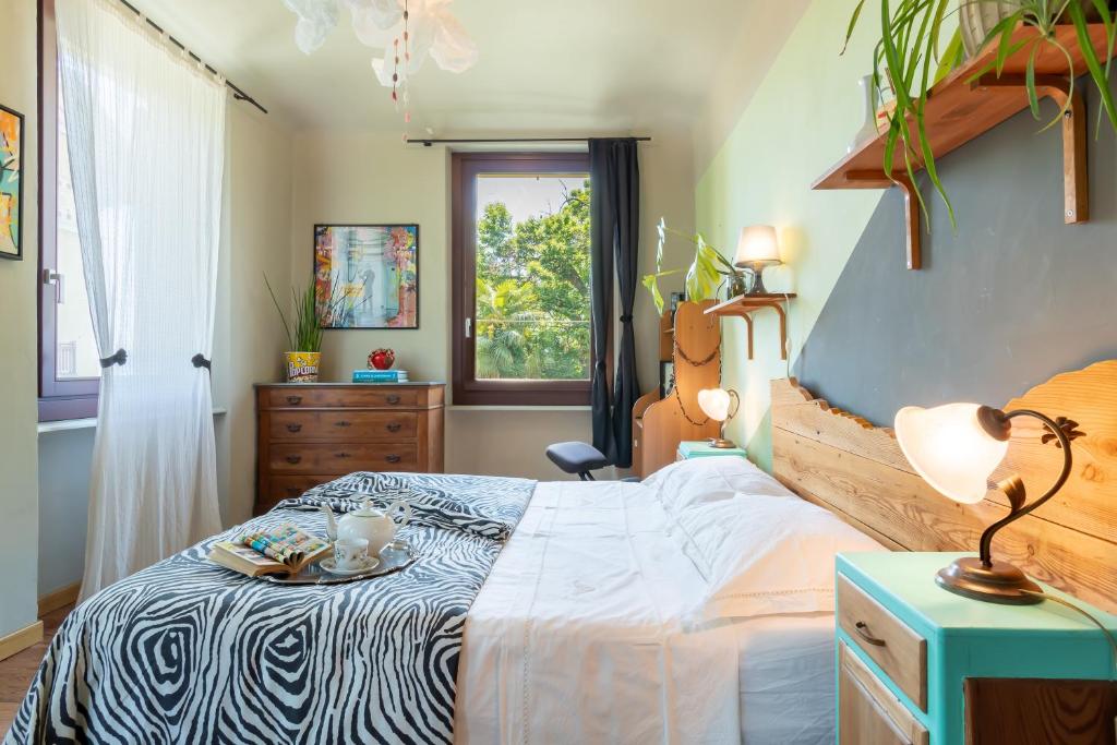 a bedroom with a bed and a table with a plate on it at Aurorina, appartamento con giardino in Torre Pellice