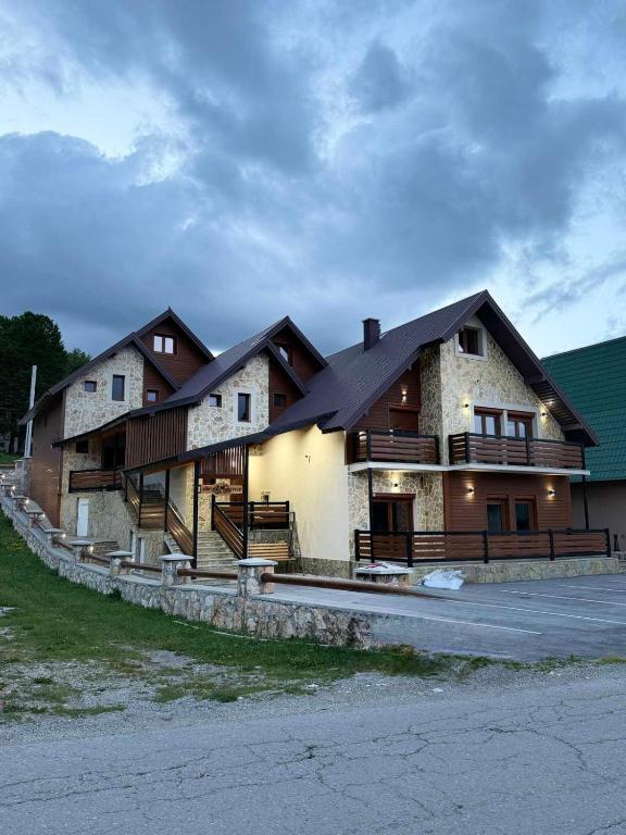 a large house with a black roof at Tri ville in Žabljak