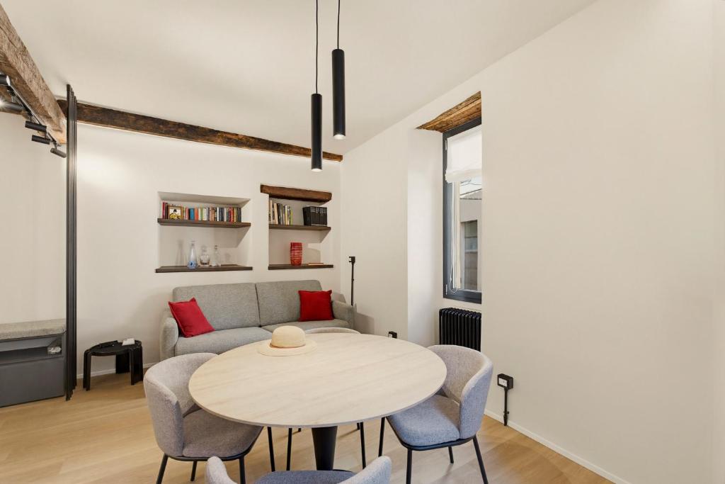 a living room with a table and chairs and a couch at Iseo Vicolo Portelle - indoor private parking & bike storage in Iseo