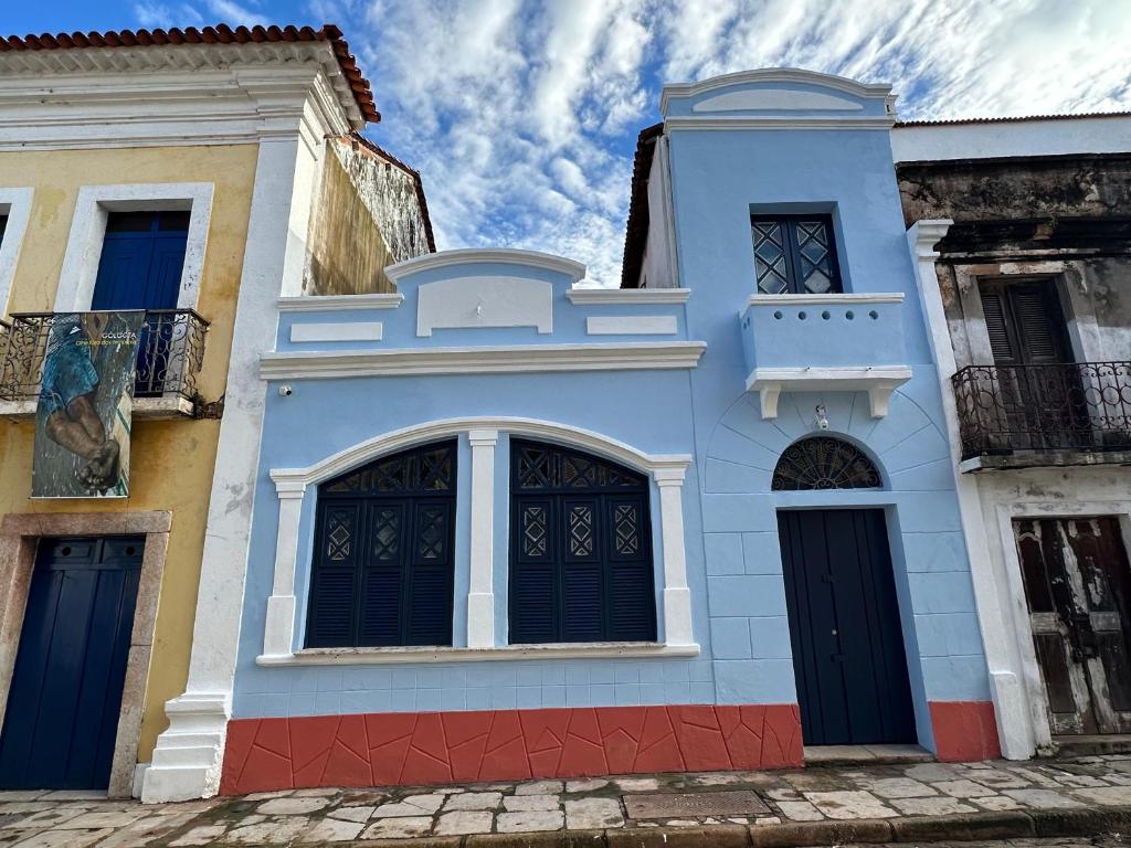 a blue building with black doors on a street at Bangalô Hospedagens in São Luís