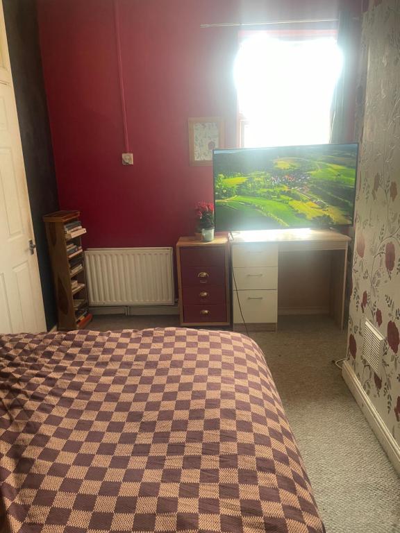 a bedroom with a bed and a flat screen tv at Wolverhampton Room in Wolverhampton