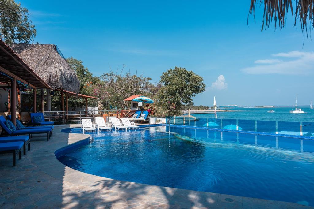 ein Pool in einem Resort mit Blick auf das Meer in der Unterkunft Hotel Isla Real in Tierra Bomba