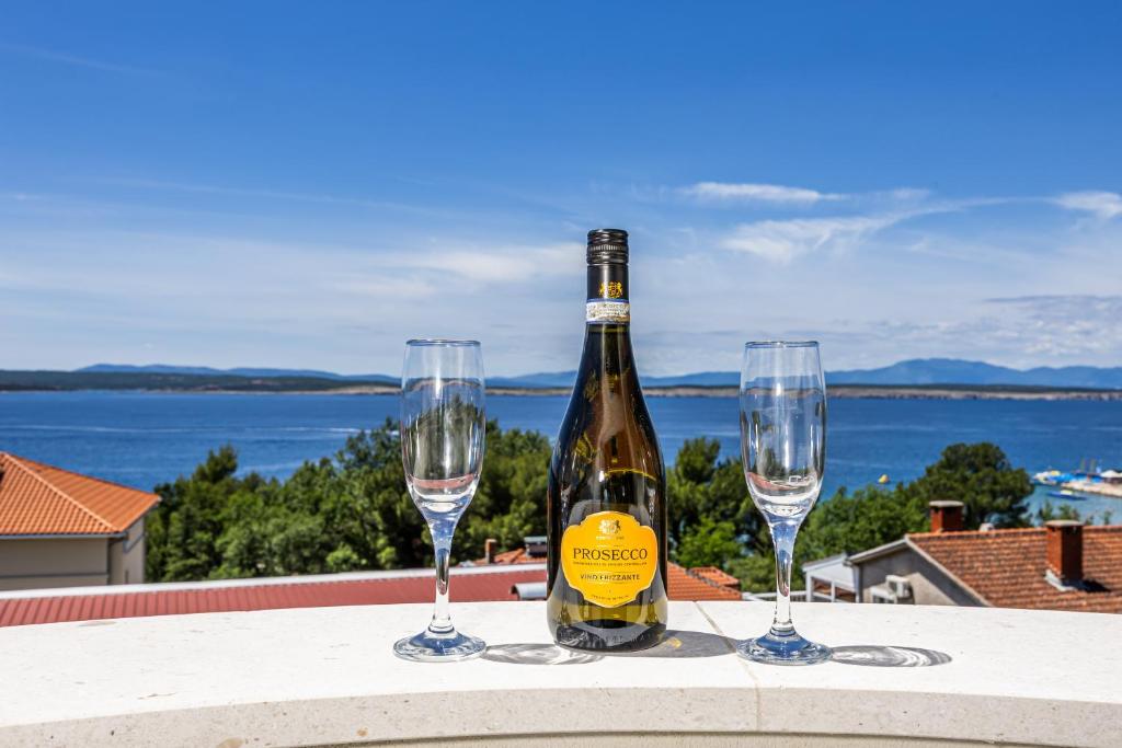 a bottle of wine and two wine glasses on a table at Villa Vita luxury Apartments in Crikvenica