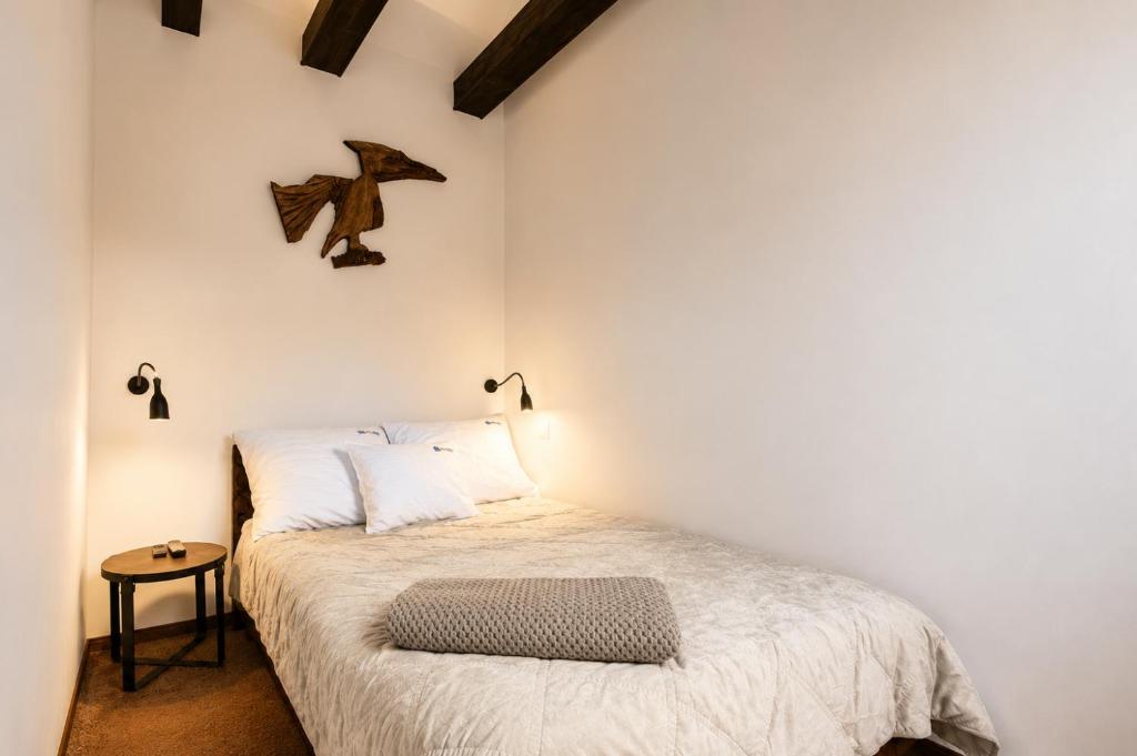 a small bedroom with a bed and a bird on the wall at Apartamenty na Fali in Mrzeżyno
