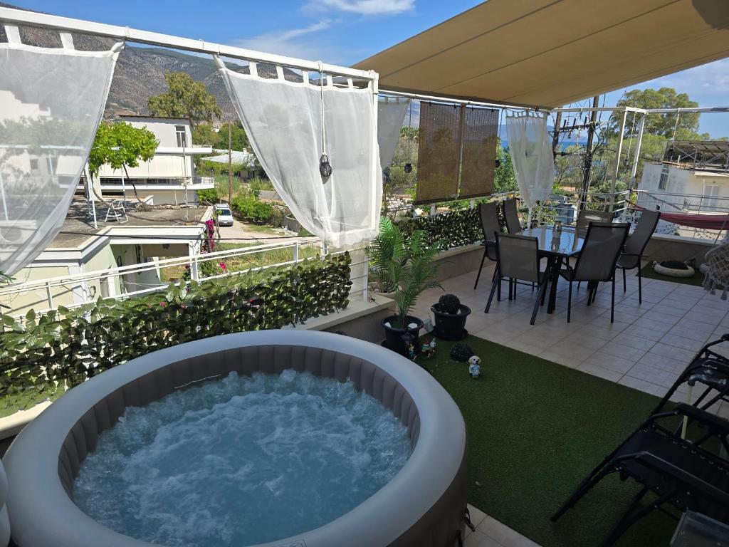 a hot tub on a balcony with a table and chairs at Delphitea Philoxenia in Itea