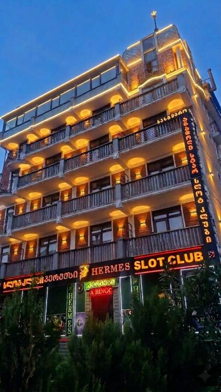 a large building with neon signs in front of it at Anadolu Hotel & Restaurant & Spa in Batumi