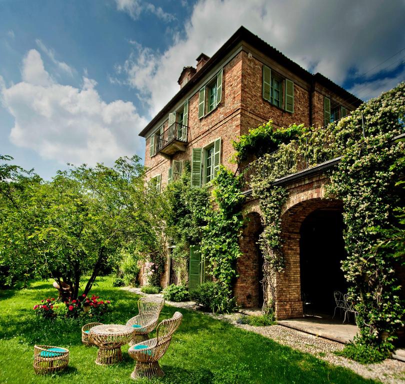 a brick house with a patio and chairs in the yard at Casa Giulia in Castagnole Lanze