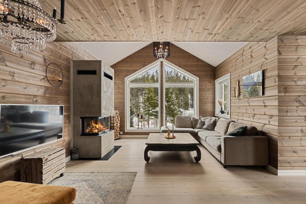 a living room with a couch and a fireplace at Cozy and modern cabin in Vossevangen