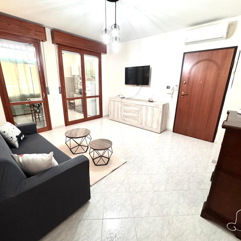 a living room with a couch and a tv at White House Quartu in Quartu SantʼElena