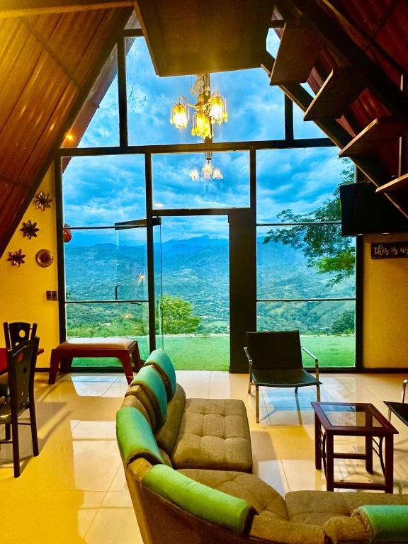 a living room with a couch and a large window at Finca Dulce Amanecer in Villeta