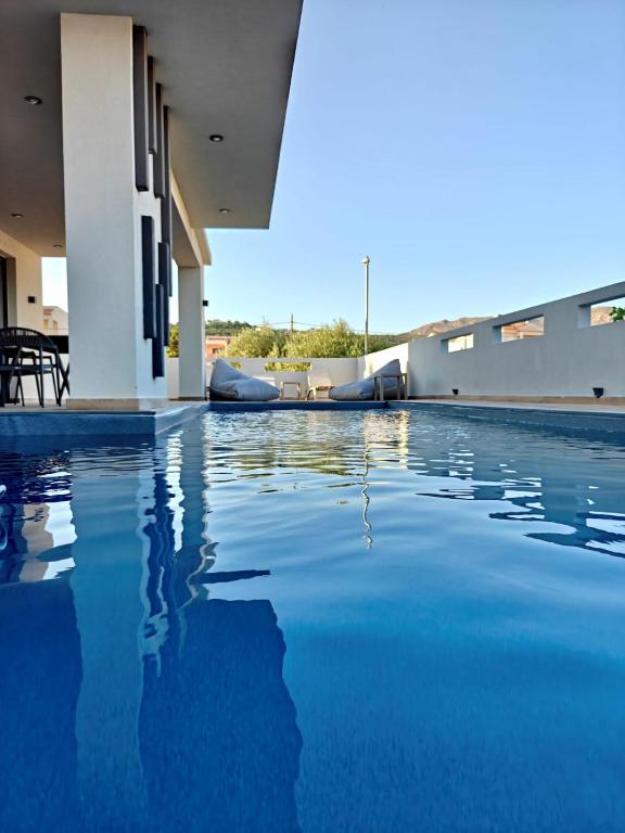 a swimming pool with blue water in a house at Aura Mare in Porto Rafti