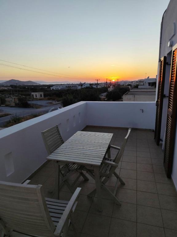 a table and chairs on a balcony with the sunset at NaxosChoraNext in Galanádhon