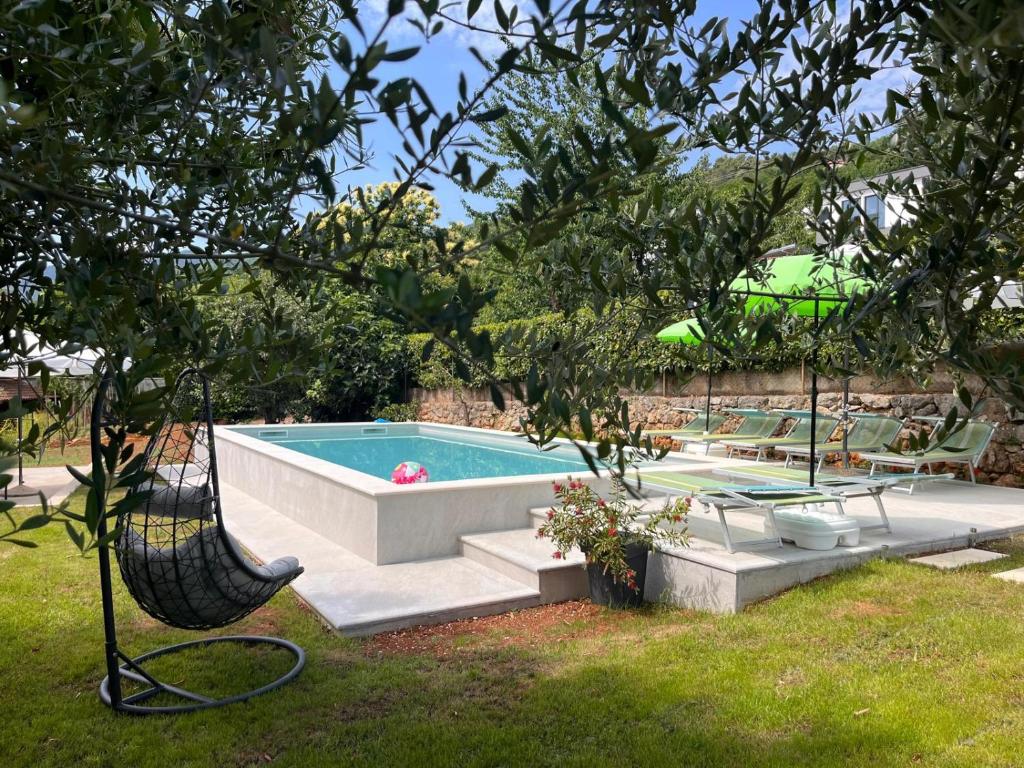 a swimming pool in a yard with a swing at Villa Riviera blue with seaview, pool, whirlpool, parking and boat excursions in Opric