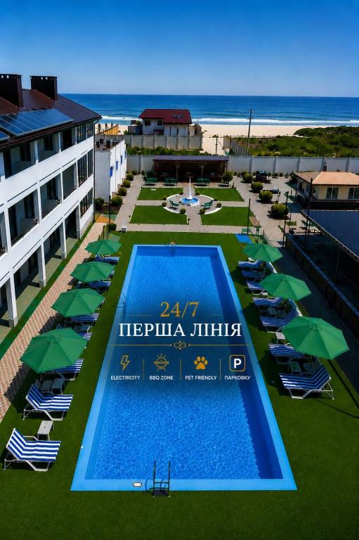 an overhead view of a swimming pool with umbrellas and the beach at Weekend Family Hotel in Karolino-Buhaz