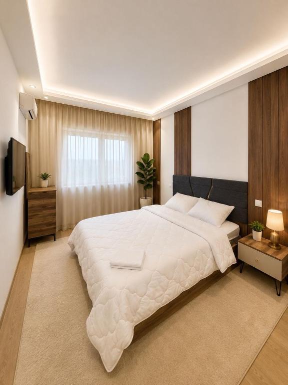 a bedroom with a large white bed and a television at Residence vigier in Tangier