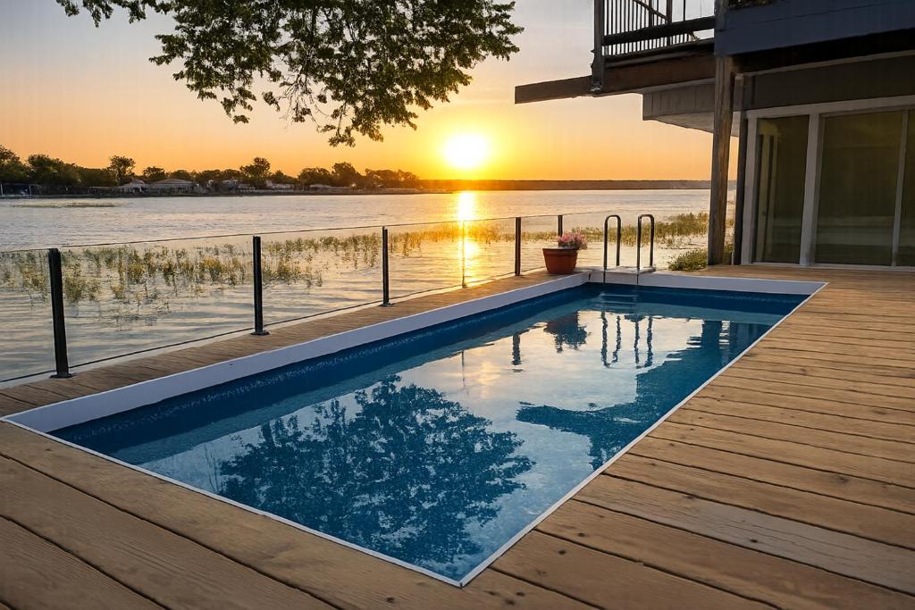 a swimming pool on a deck with a view of the water at Lakefront withTreehouse & Pool, Hottub, Gameroom in Azle