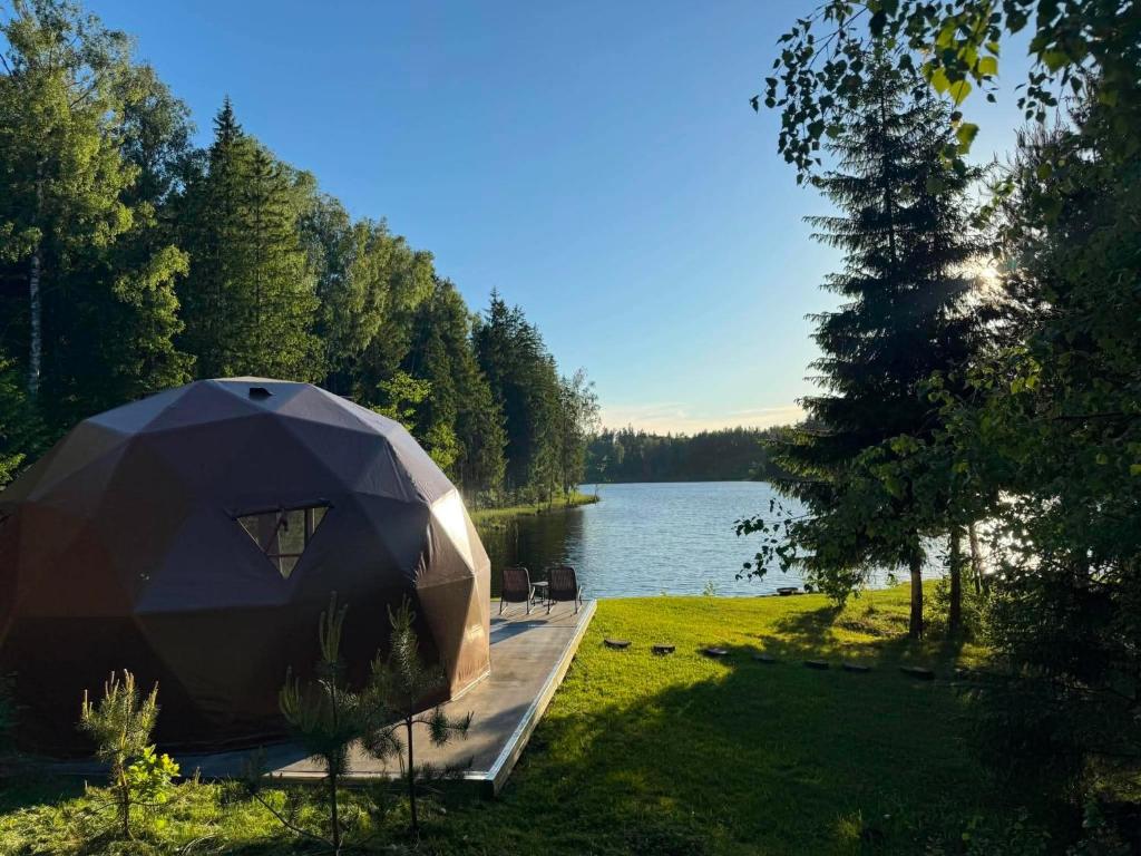 a tent is parked next to a body of water at Miško Perlas in Buožėnai