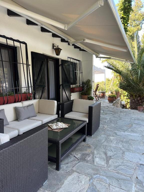 a patio with a white couch and a table at The Gift Sani Villa in Sani Beach