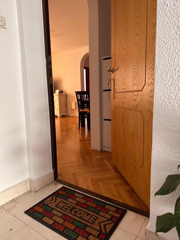 a door leading into a hallway with a rug on the floor at Sirius Apartment in Škaljari
