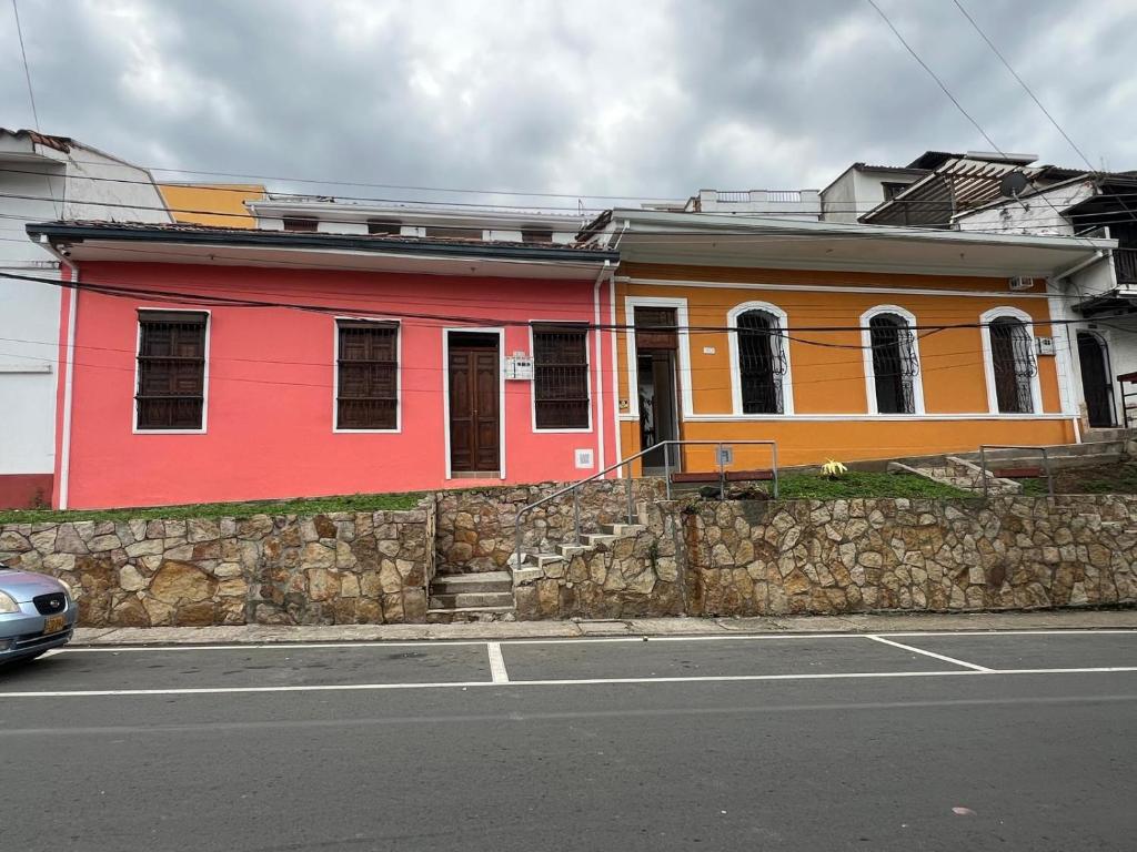 a red and orange building on the side of a street at Tángara Home in Cali