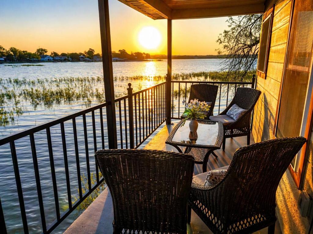 a porch with chairs and a table with a view of the water at Lakefront Retreat, Pool, Hottub, Firepit in Azle