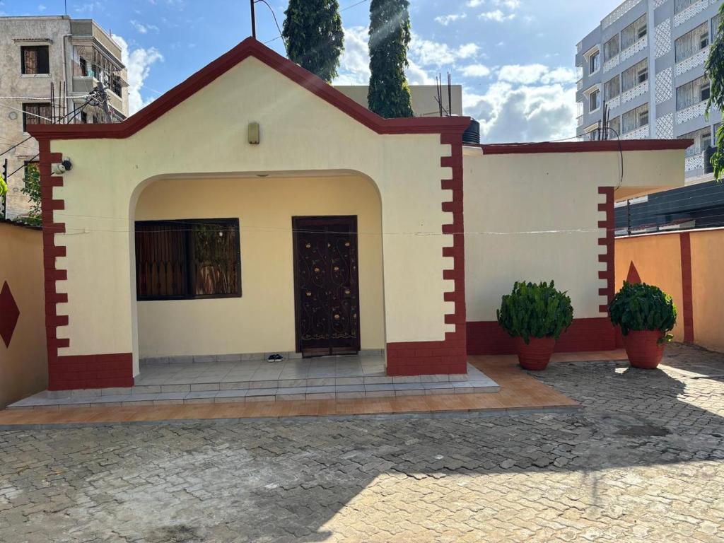 a small house with a door in a courtyard at Barizi Cottage in Tulu