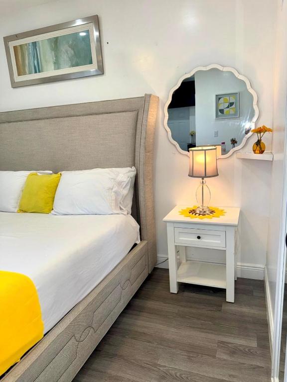 a bedroom with a bed and a table with a lamp at Private Cozy Studio in Sunrise