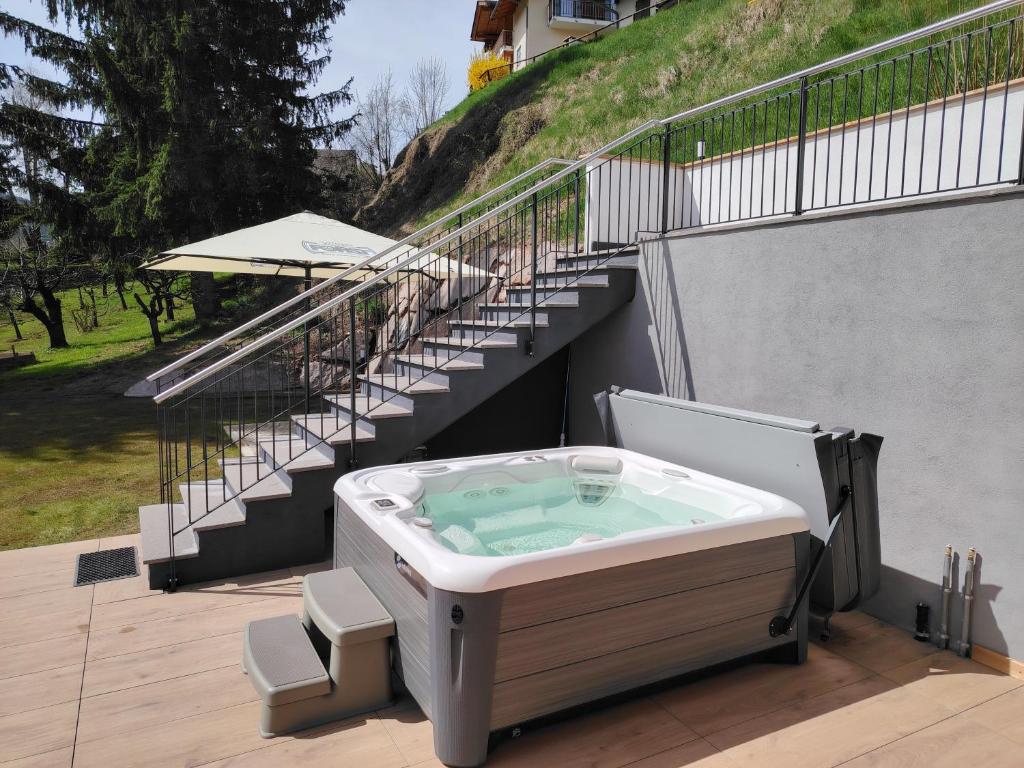 a hot tub sitting on a deck with stairs at MOUNTAIN DELUXE 27 APARTMENTS con WELLNESS in Cavalese