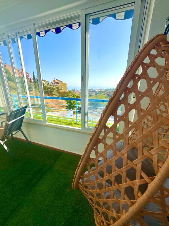 a room with a chair in front of a window at Oasis de Málaga in Chilches
