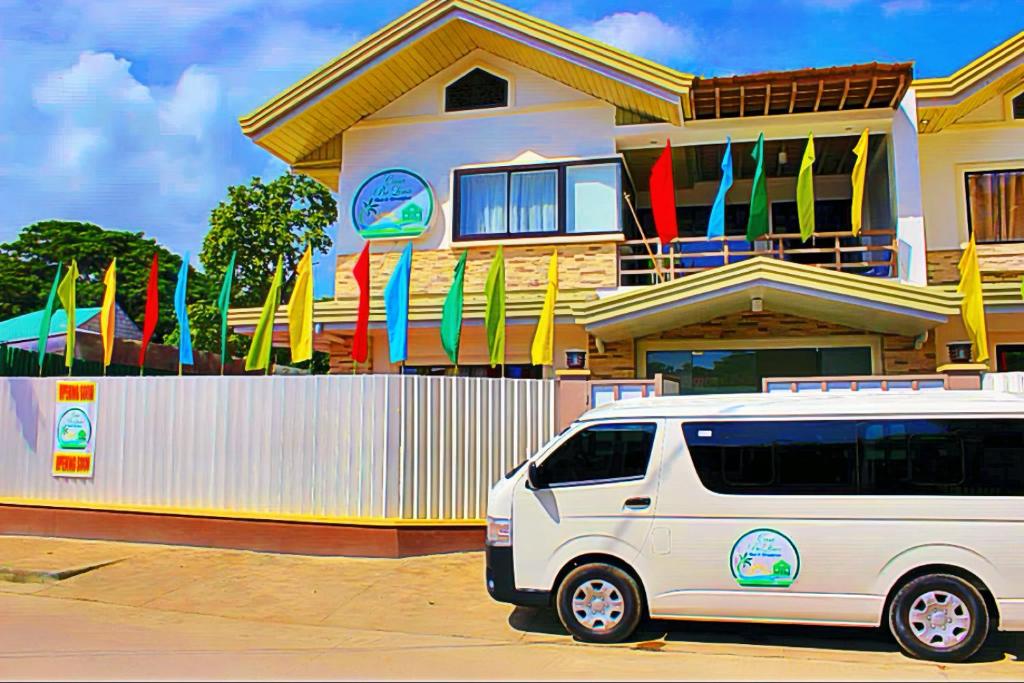 a white van parked in front of a building with flags at Casa Belina in Puerto Princesa City