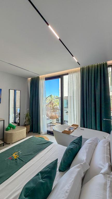 a bedroom with a large bed with green pillows at TreA Suites By Aria in Vlorë