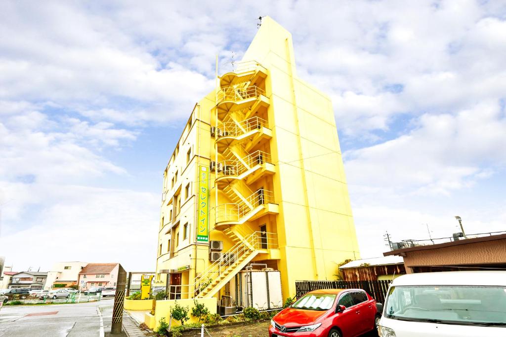 a yellow building with a yellow staircase on it at Select Inn Yaizu Ekimae in Yaizu