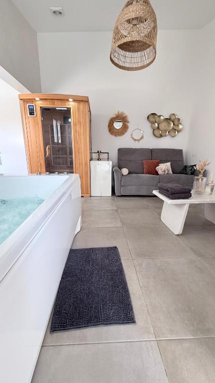 a living room with a couch and a table at SPA JUNGLE in Le Mesnil-Saint-Denis