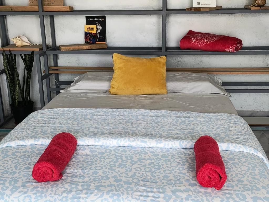 a bed with two red knitted towels on it at Casa Tonatih in Mexico City