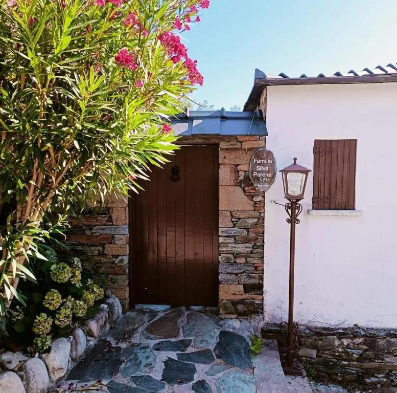 a house with a wooden door and a street light at Casa dos avós 23 in Castro Daire