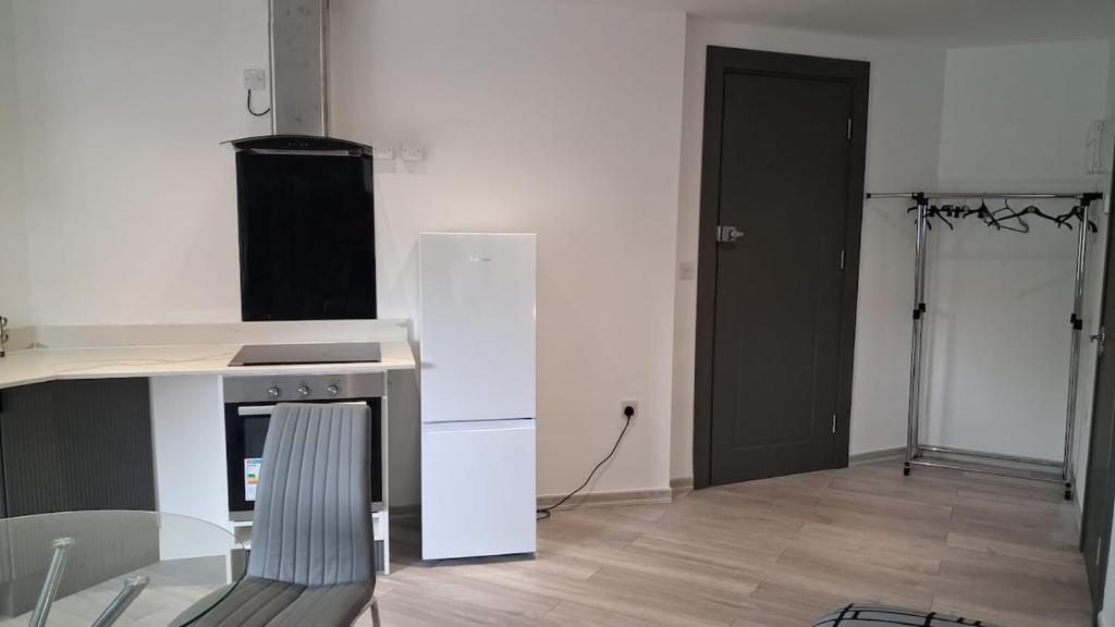 a kitchen with a white refrigerator and a black door at Modern Studio Apartment with En-Suite in Peterborough