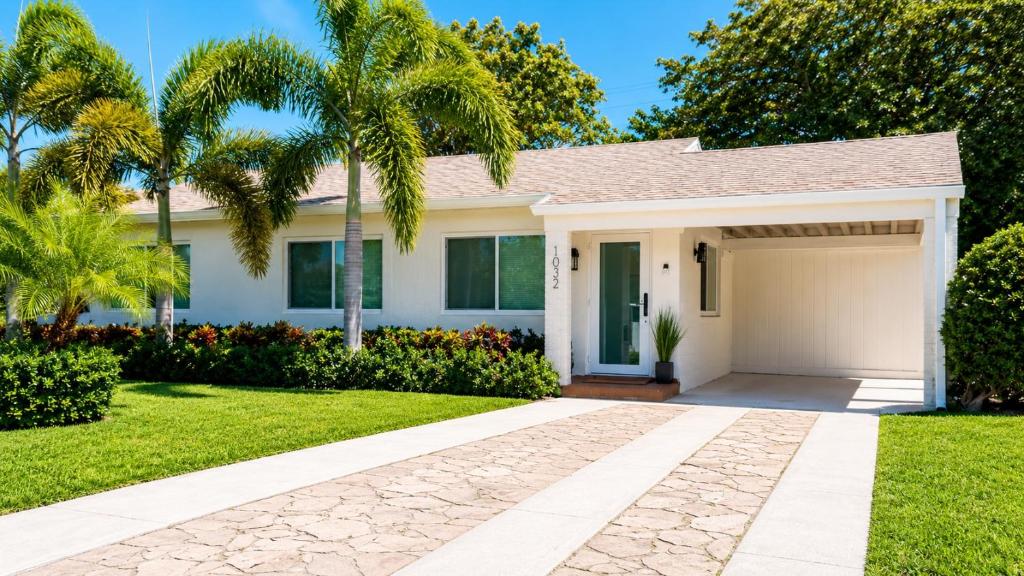a house with palm trees and a driveway at Tropical Oasis 3 Bedroom House with Hot Tub West Palm Beach in West Palm Beach