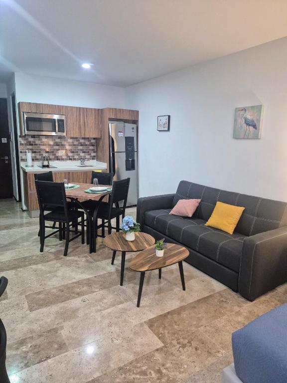 a living room with a couch and a table at Tu estancia perfecta - ubicación y privacidad in Playa del Carmen