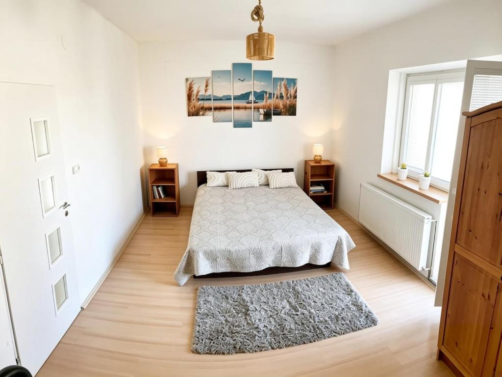 a bedroom with a bed and a rug at Apartment by the lake in Píšťany