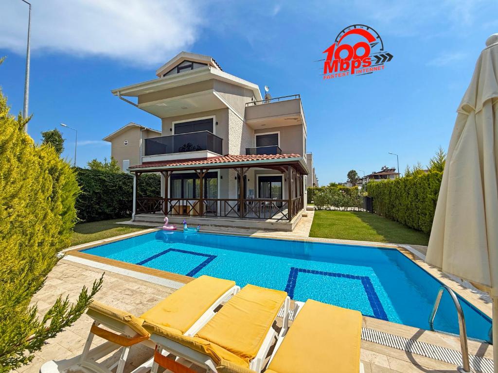 a villa with a swimming pool in front of a house at Paradise Town Villa Belhamra in Belek
