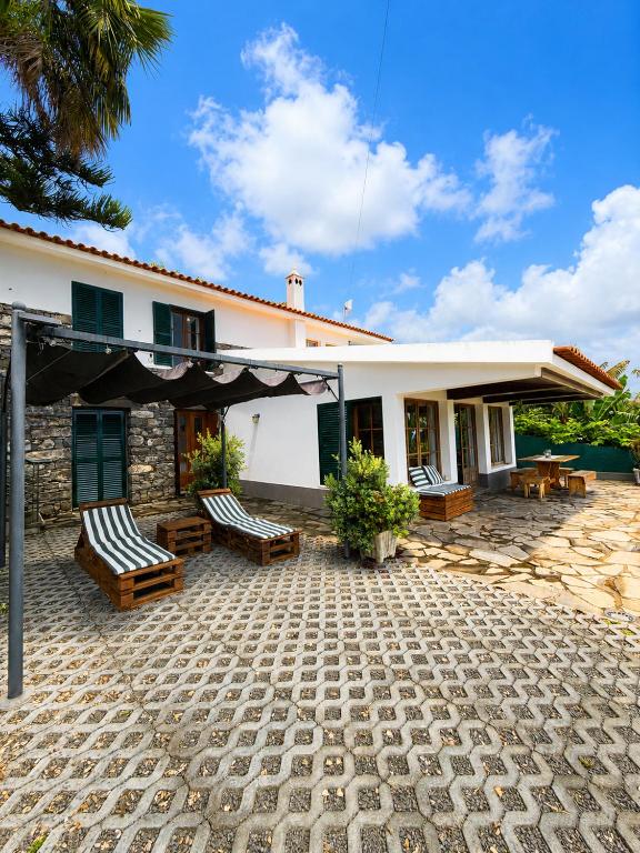 a house with two chairs and a patio at Dr. Cabral Barreto in Ponta do Sol