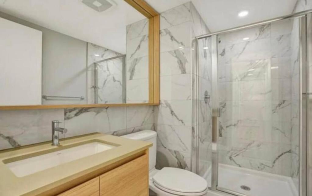 a bathroom with a shower and a toilet and a sink at Cozy private bedroom and bathroom in Surrey