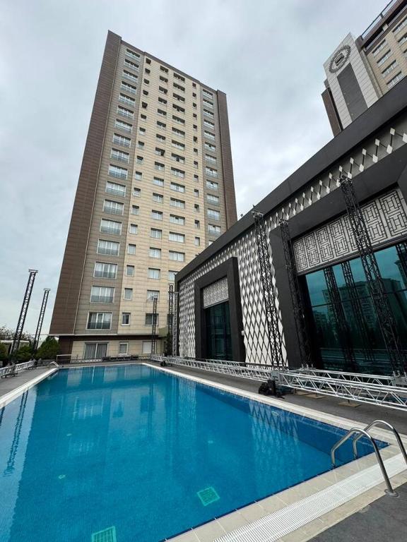 a large swimming pool in front of a building at Sheraton Apartments in Bishkek