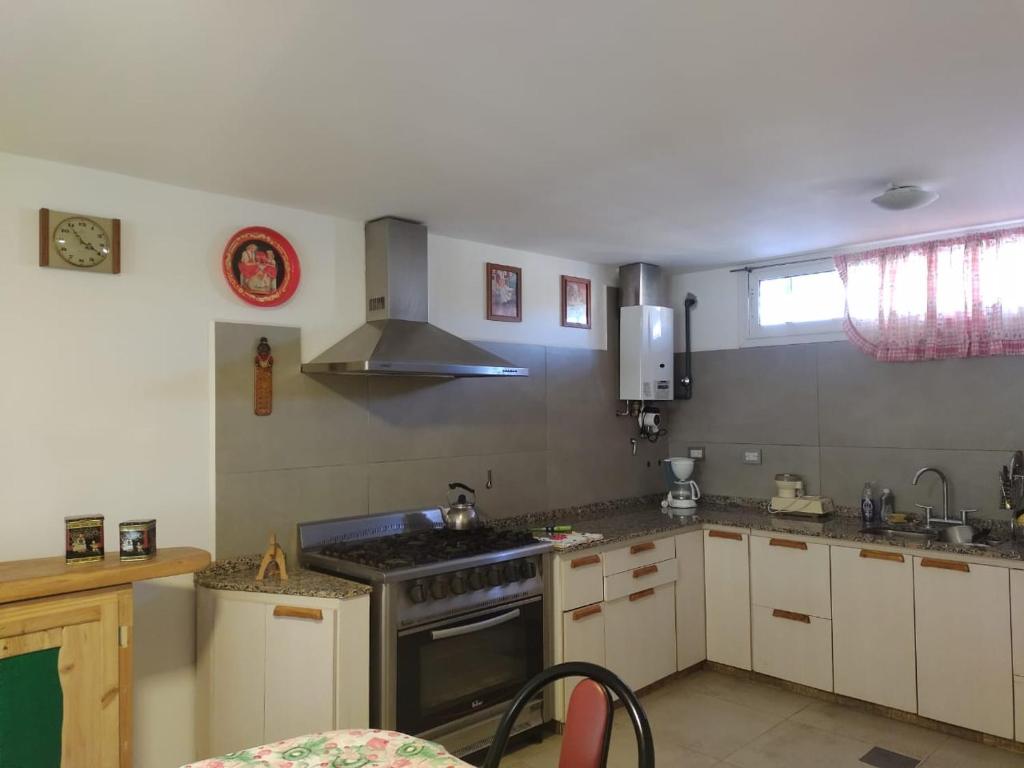 a kitchen with white cabinets and a stove top oven at Casa XENA in Río Cuarto