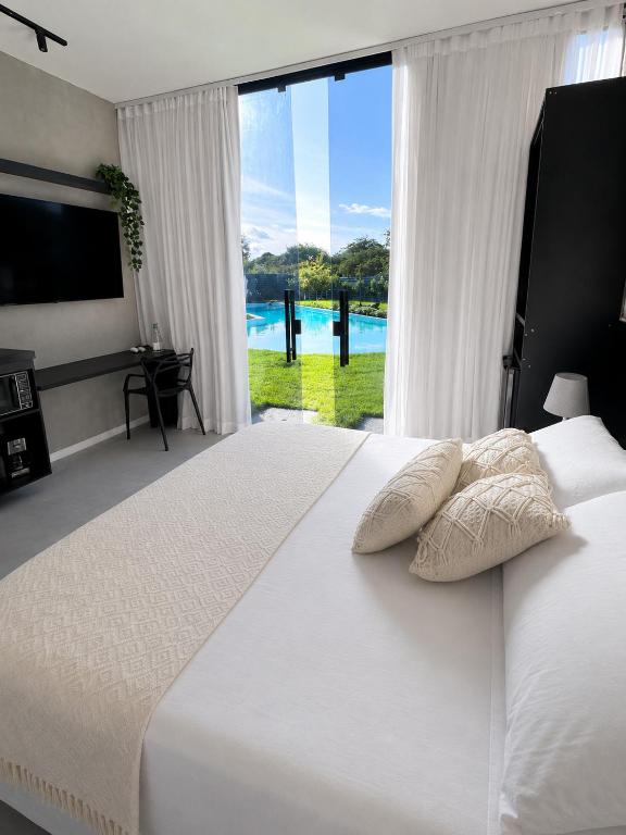 a bedroom with a large white bed with a large window at Luce del sole bangalô in Fortim