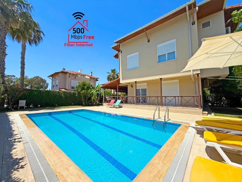 a villa with a swimming pool and a house at Paradise Town Villa Orchard in Belek