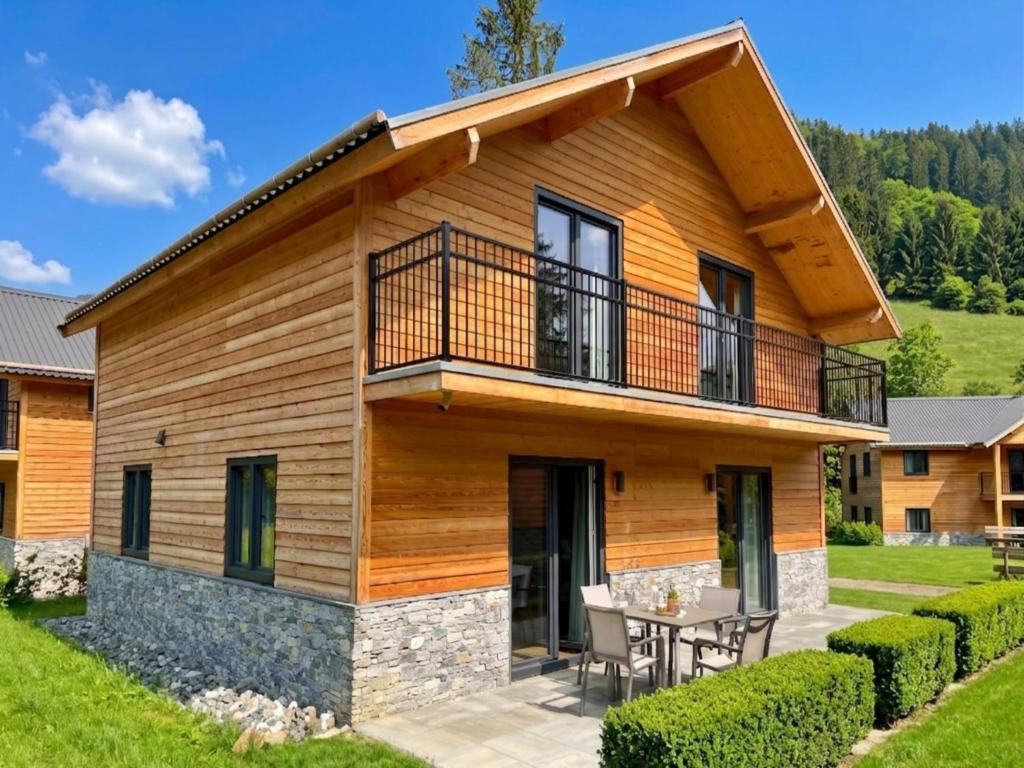 a log home with a balcony and a table at Nockberge in Afritz