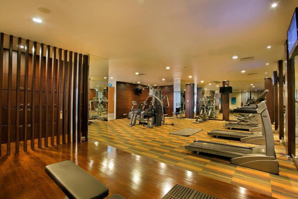 ein Fitnessstudio mit Laufbändern und Crosstrainern in der Unterkunft HARRIS Hotel & Conventions Malang in Malang