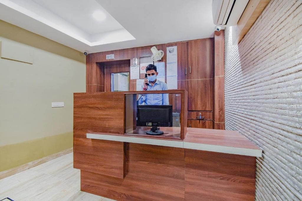 a room with a tv on a table with a mirror at Hotel O Tranquil Stay in Kolkata